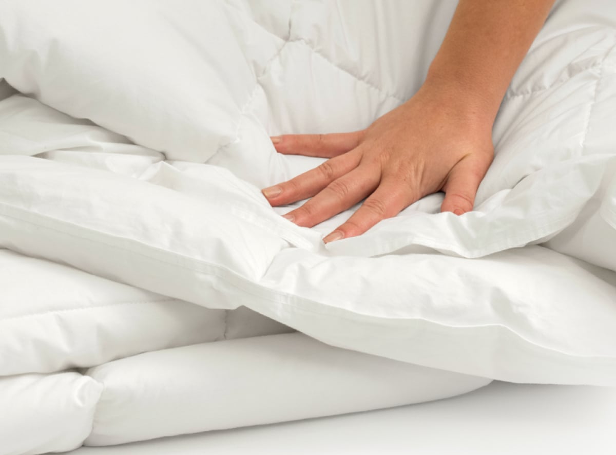 A closeup of the Duvet Insert with a hand pressing into its plush surface