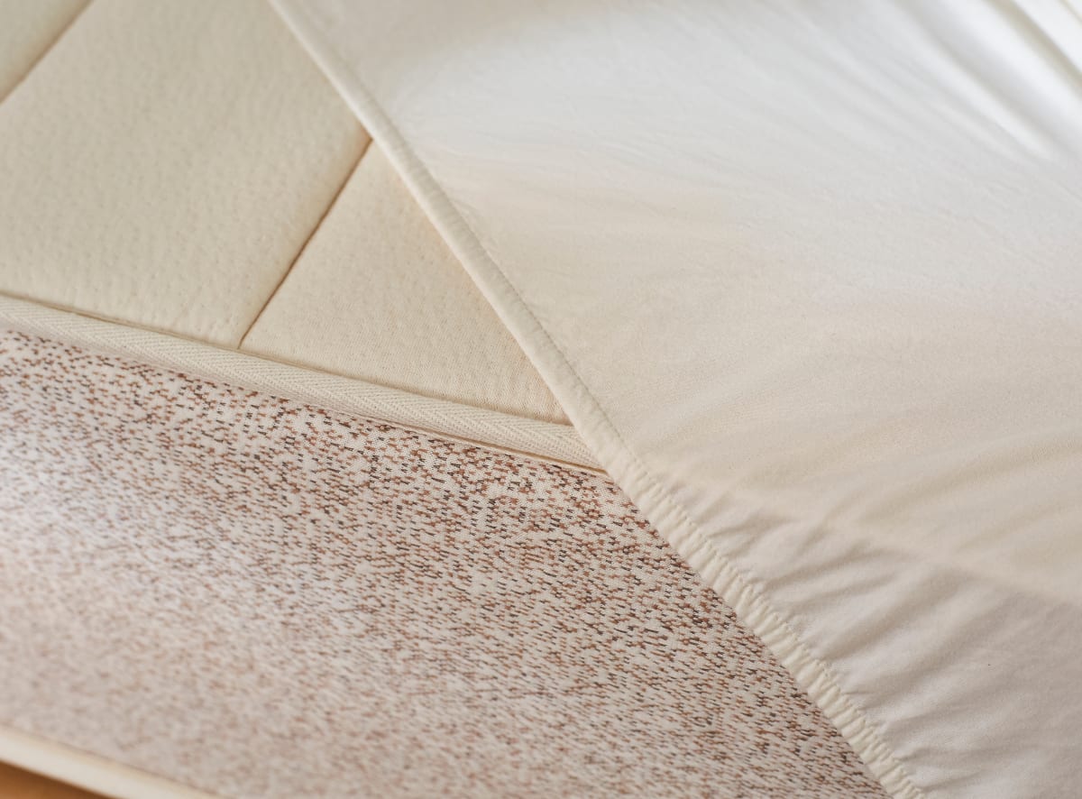 A closeup of the mattress protector showing the skirted design