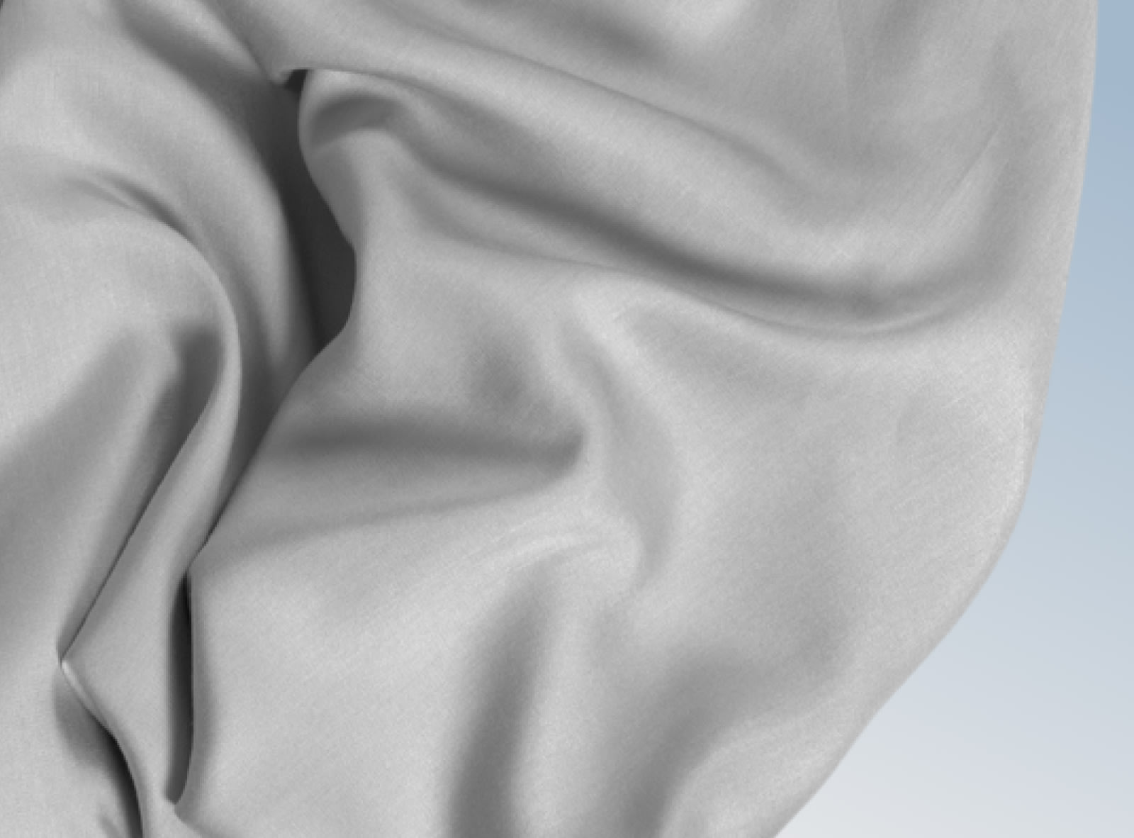 Silver tencel sheets rumpled on a blue background