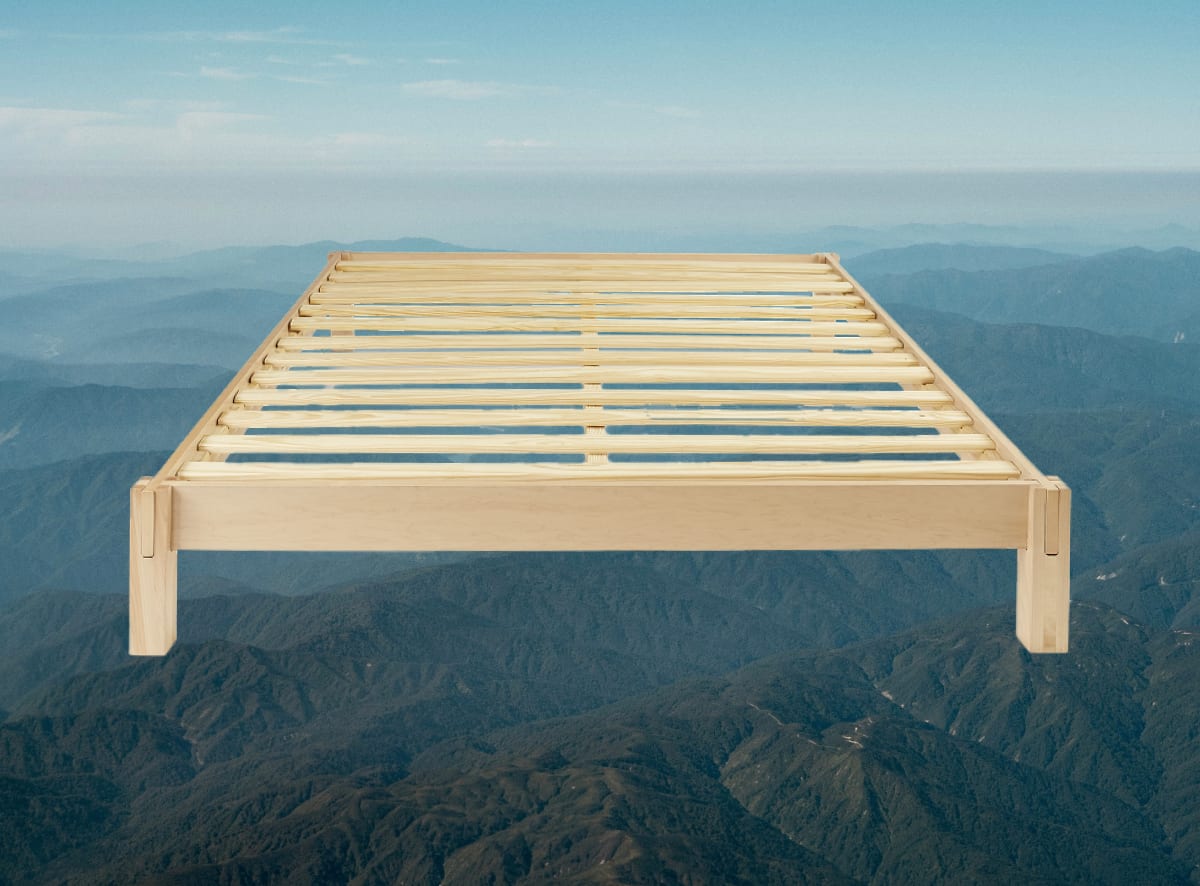 A product image of the Madison Bed Frame on a mountain scene background