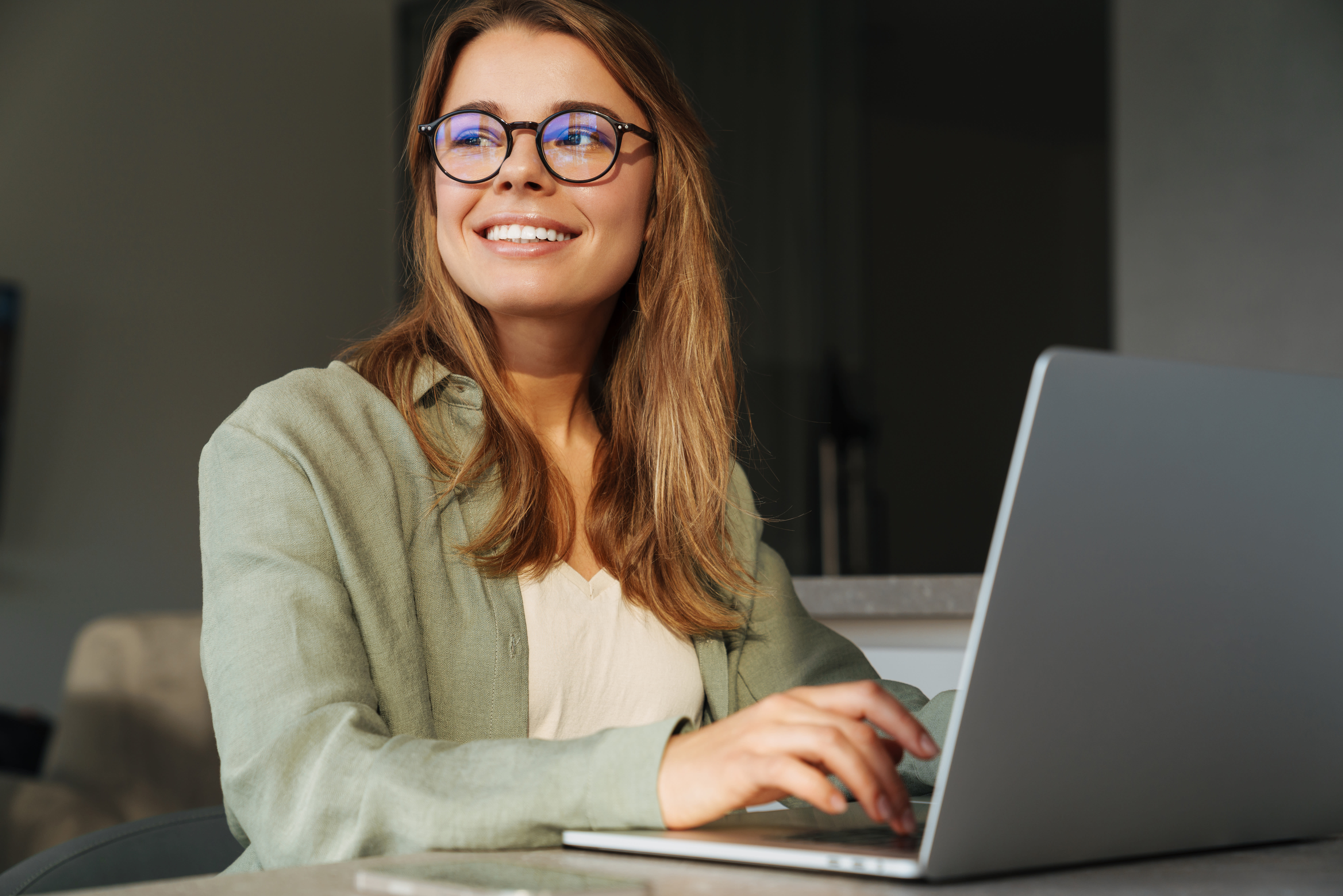 Woman smiling talking to customer support on computer.
