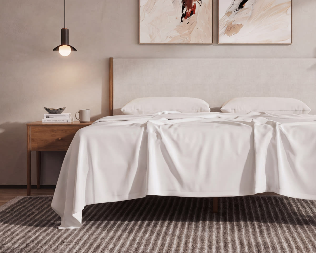 A rendered image of the CoolShift Sheet Set laid across a bed in a bedroom scene