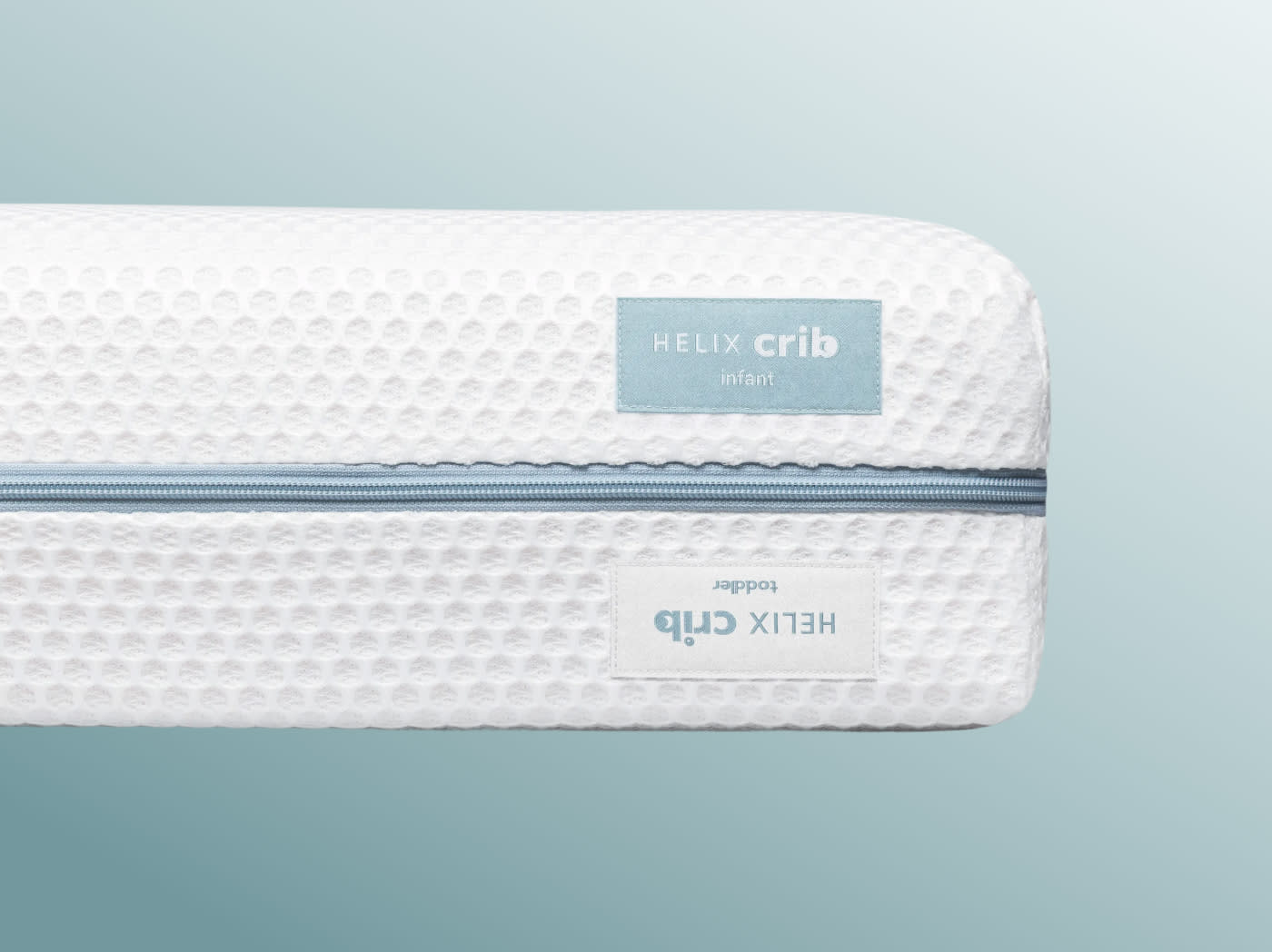 A closeup image of the Crib Mattress cover showing it covers both sides of the flippable crib mattress