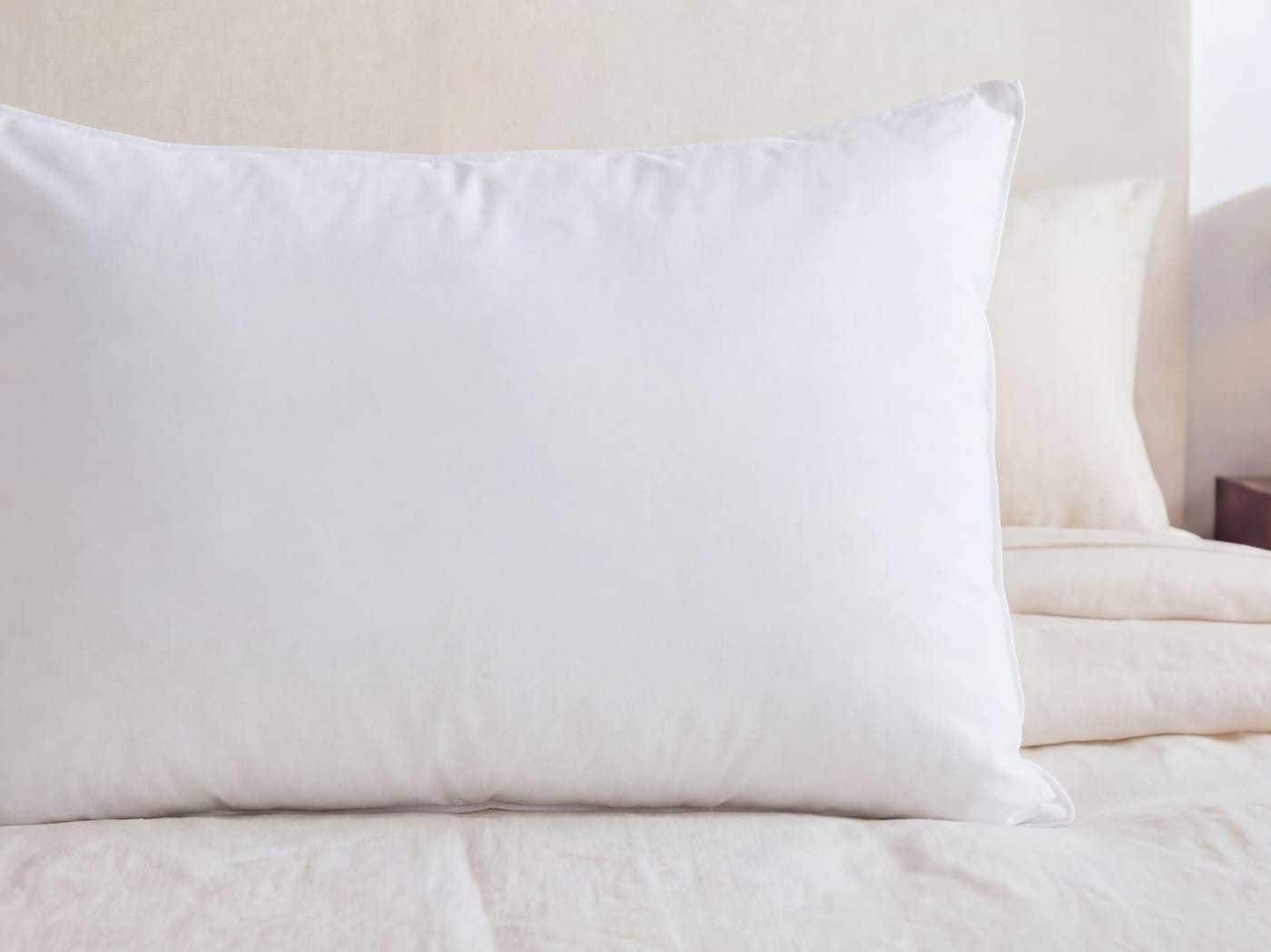 A closeup of the Down and Feather pillow on a bed