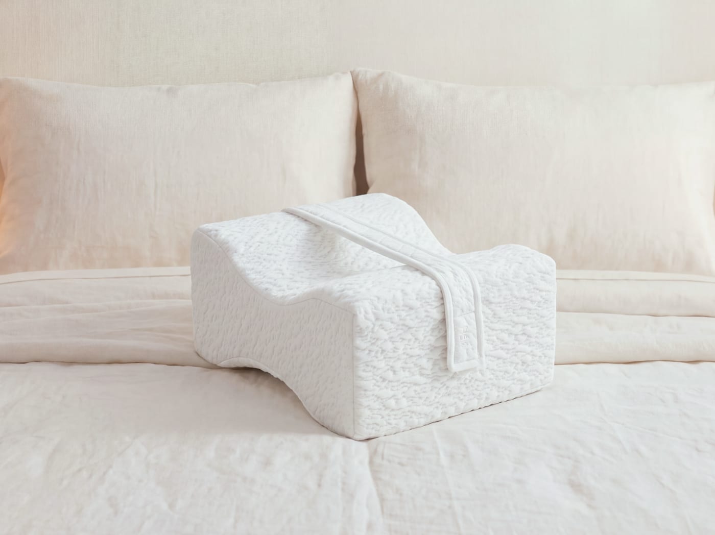 An image of the side sleeper knee pillow on a bed