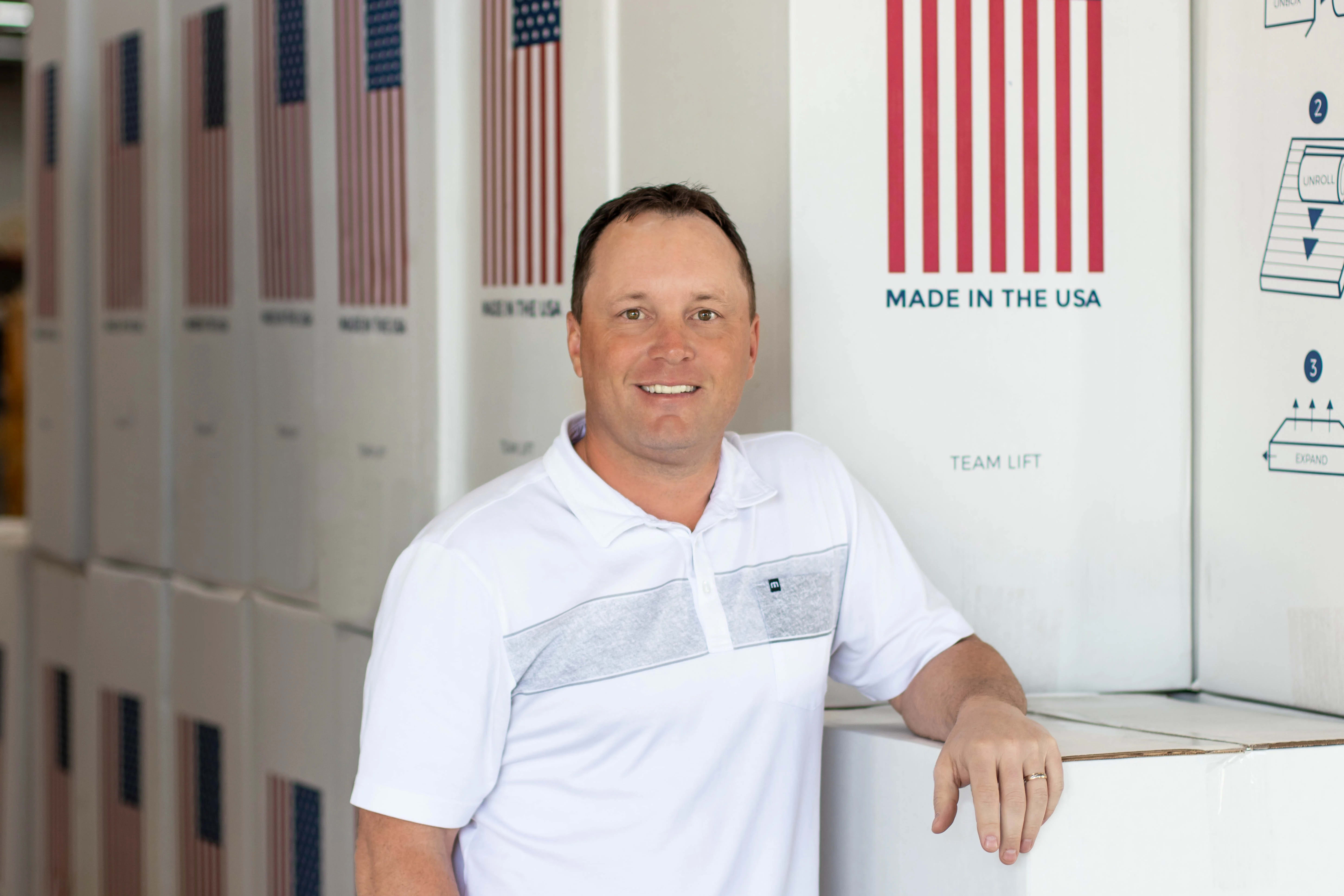 Brooklyn Bedding Owner John Merwin in front of mattress boxes