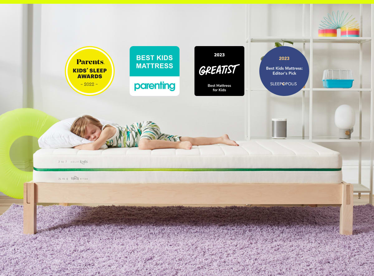 Child sleeping on Helix Kids Mattress with awards badges overlaid on the image