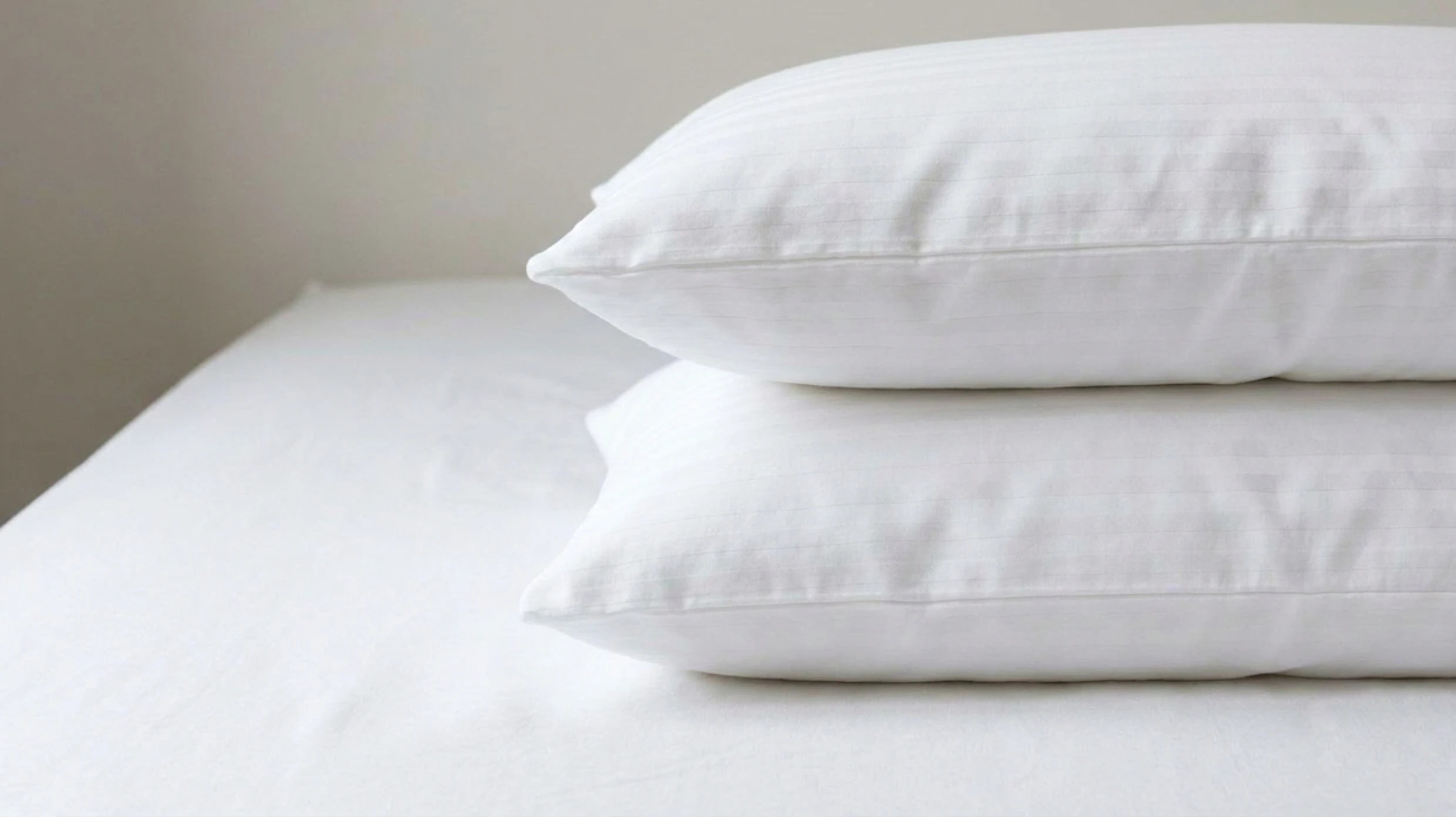 An image of two Dream Pillows stacked together on top of a mattress