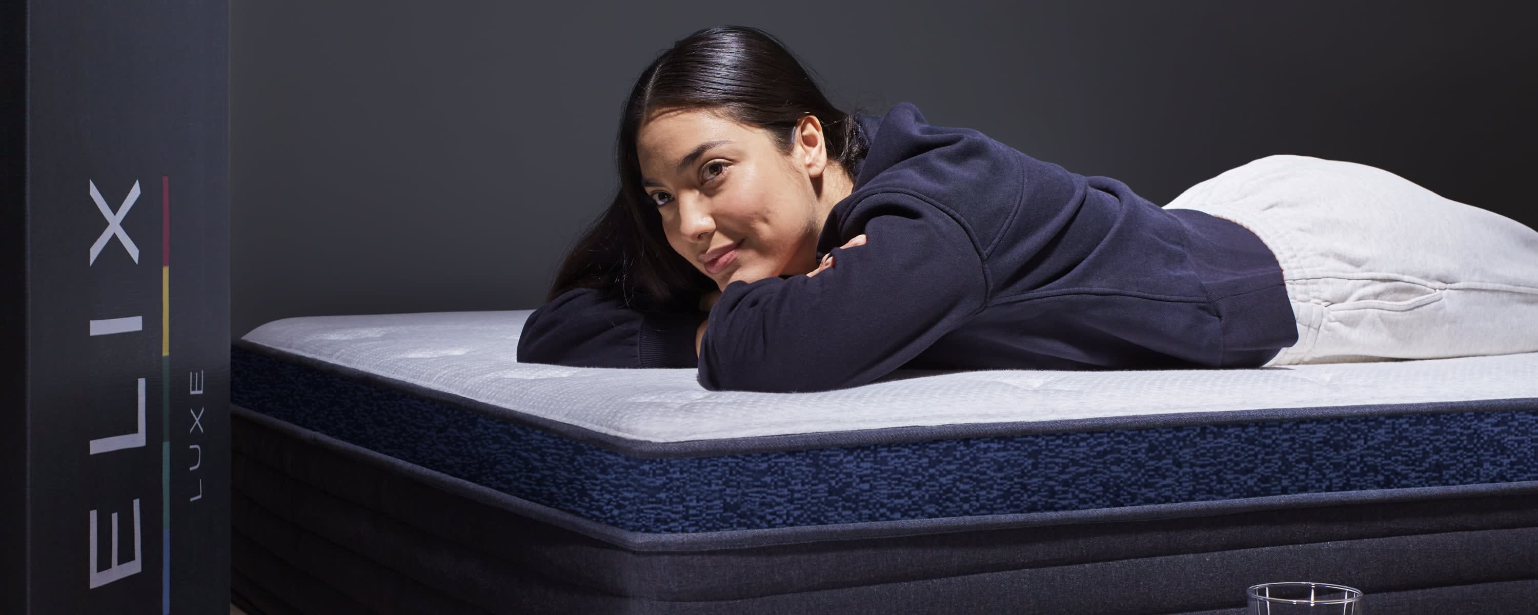 Person laying on Luxe Midnight mattress