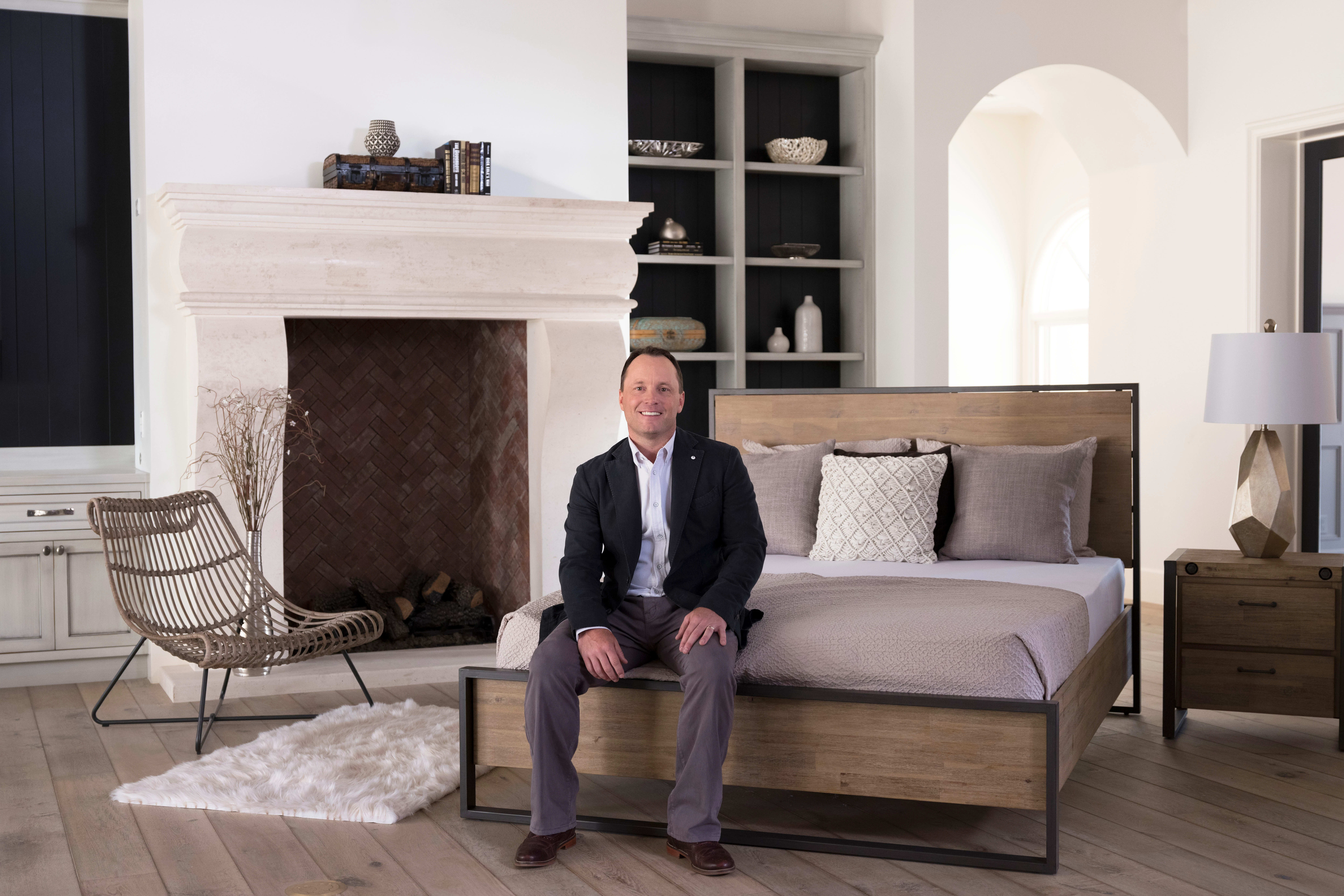 Brooklyn Bedding Owner John Merwin sitting on bed in bedroom