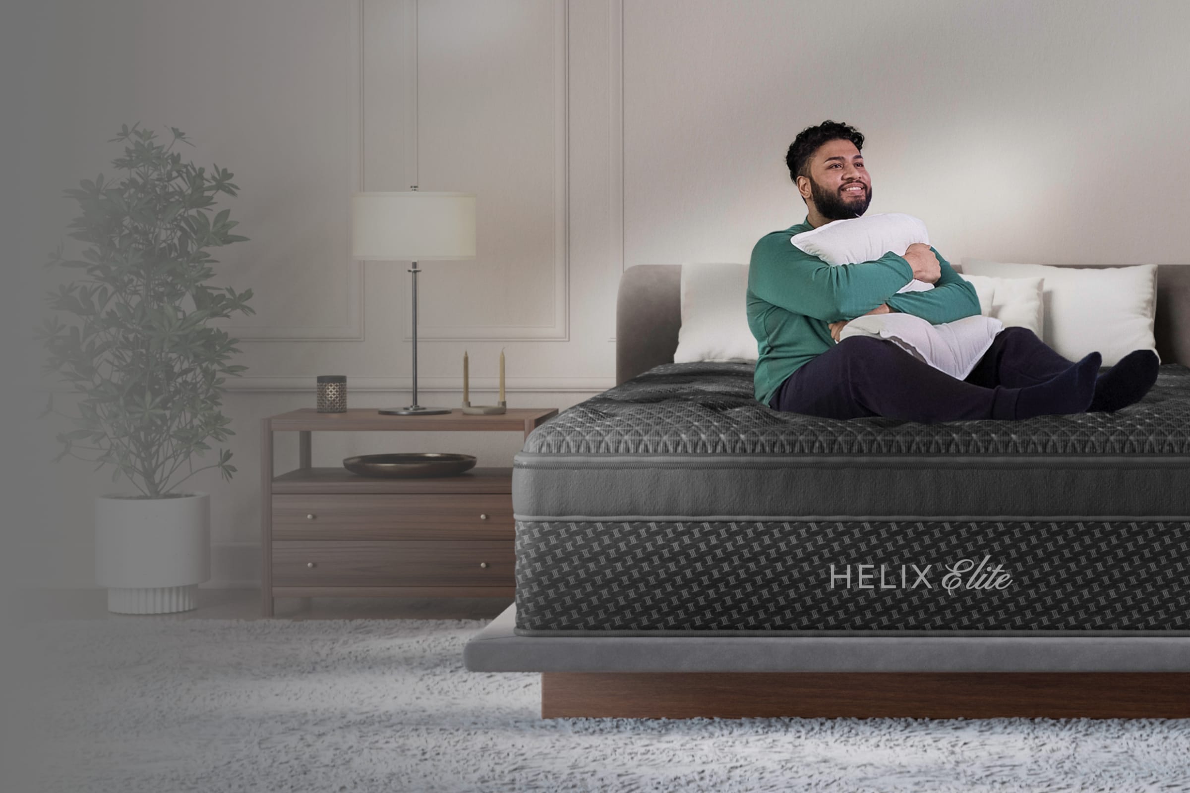 A lifestyle render showing a model on the Helix Plus Elite mattress