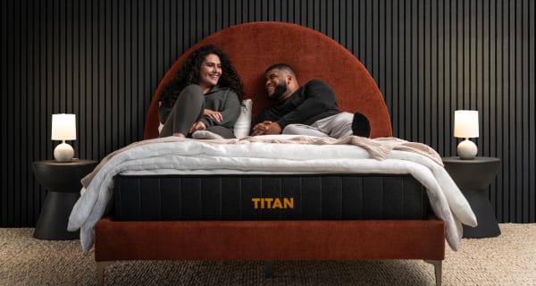 Young couple chatting on a Titan Plus in a luxury bedroom