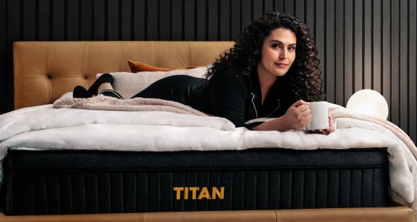 Young woman laying on Titan Plus Luxe in a luxury bedroom
