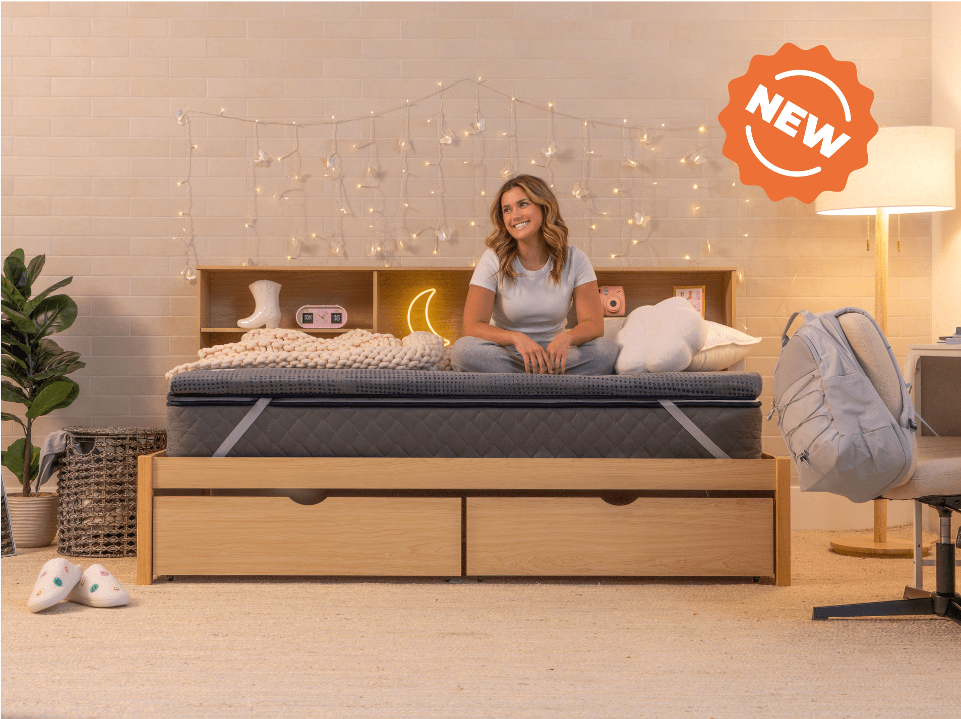young woman sitting on copperflex 201 mattress topper in a dorm room