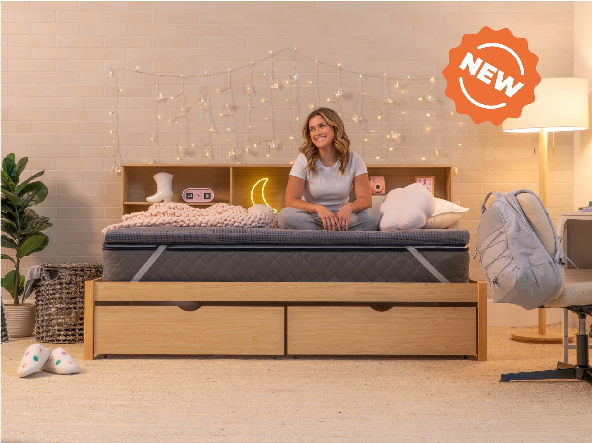 young woman sitting on copperflex 201 mattress topper in a dorm room