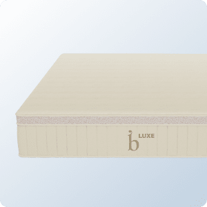 A product image of the Birch Luxe Natural mattress on a blue background gradient
