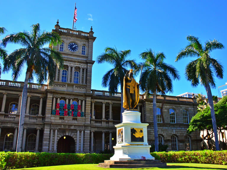 卡美哈美哈國王雕像，背景為伊奧拉尼宮（Iolani Palace| ©Edmund Garman