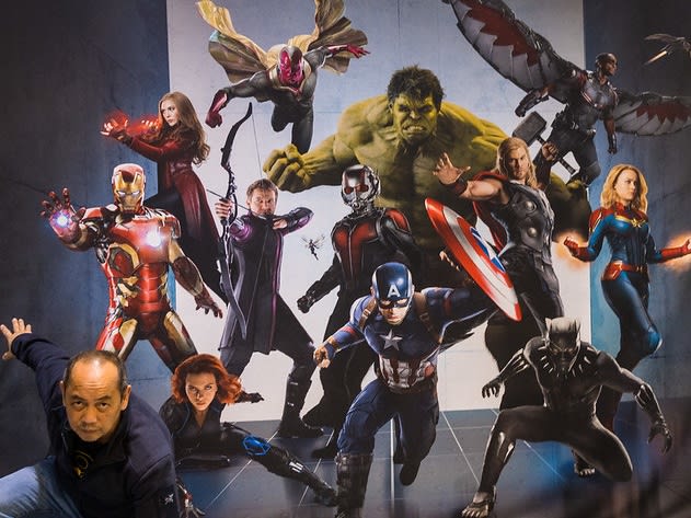 man posing in front of Avengers poster| ©A DeVigal