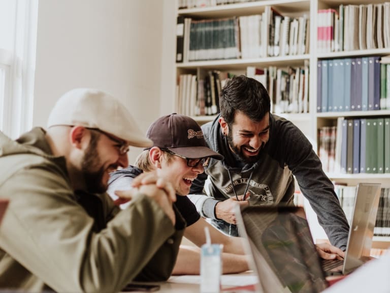 tre uomini che sorridono al portatile|© Priscilla Du Preez
