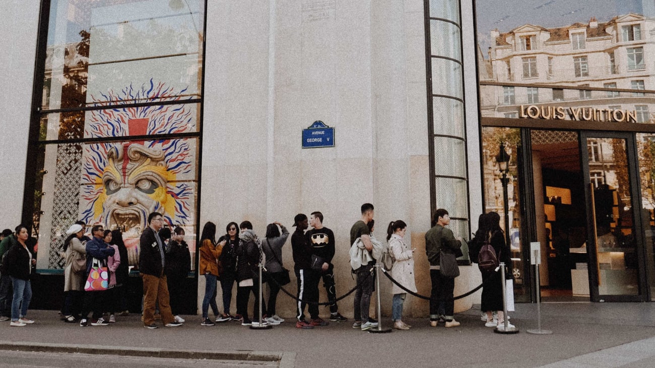 Queue of shoppers outside Louis Vuitton store on Champs Elysees in Paris  France