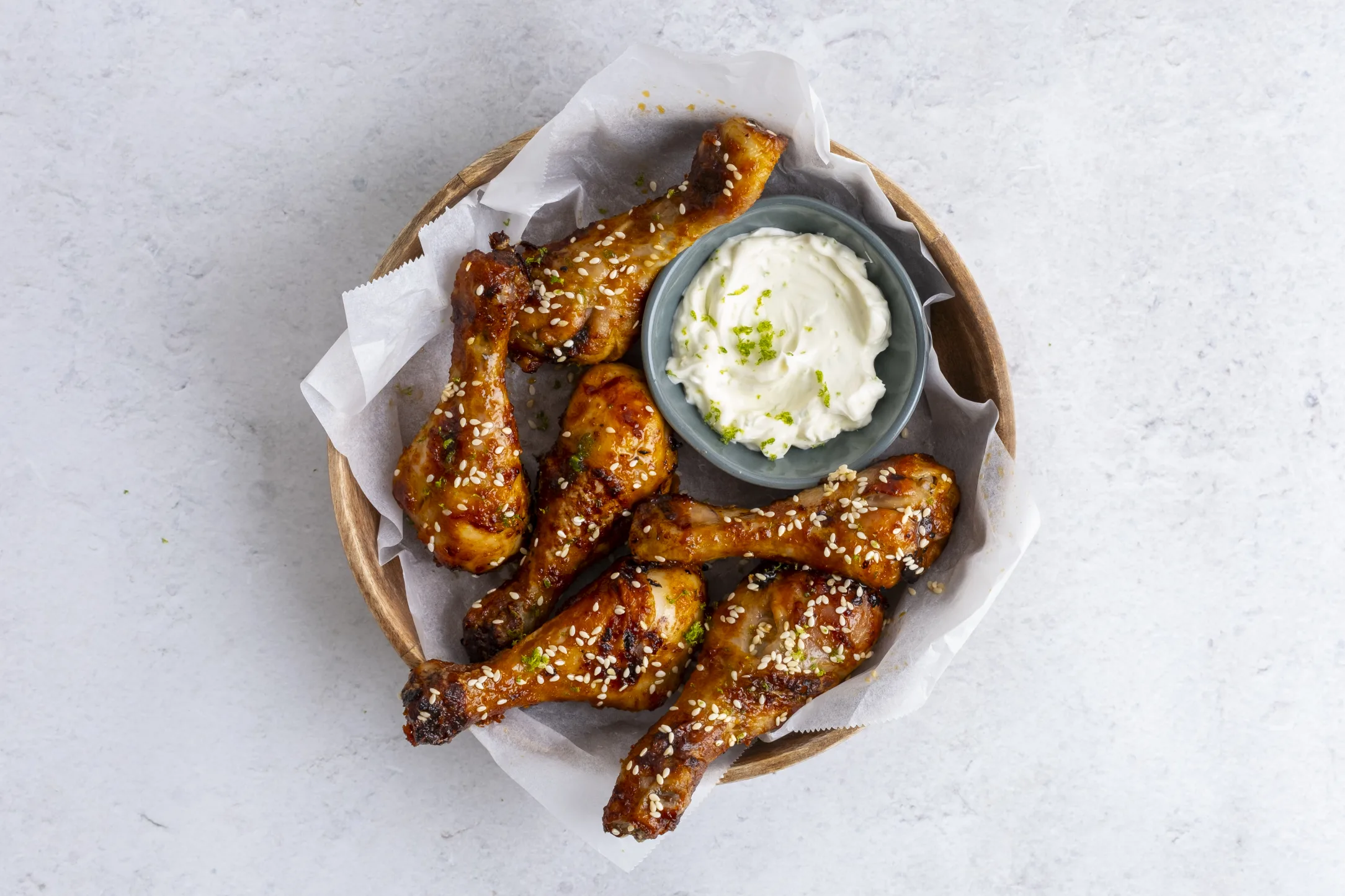 Sweet and Spicy Gochujang Chicken Drumsticks with Zesty Lime Crema