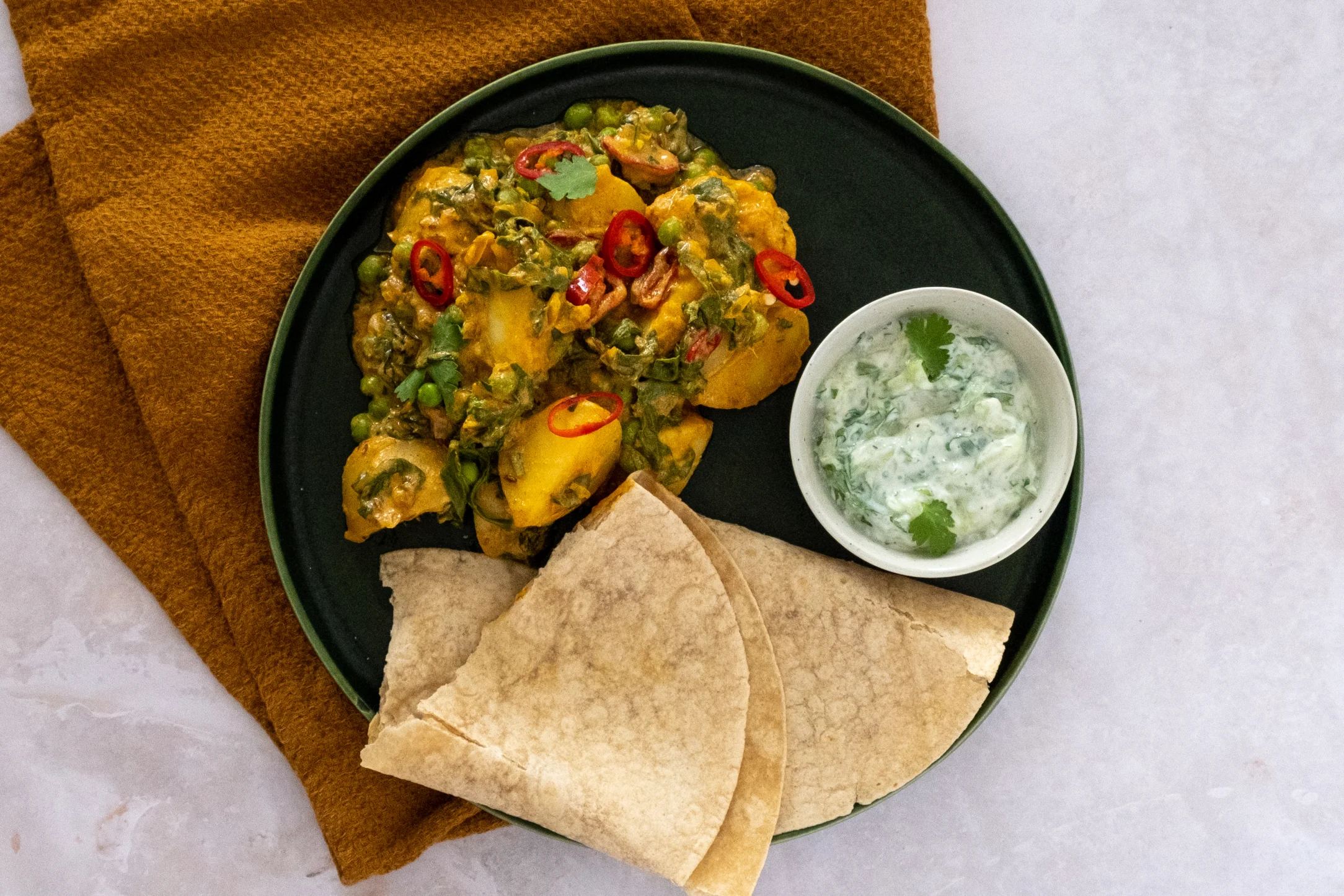 Saag Aloo: Spinach and Potato Curry with Peas, Chapati and Raita