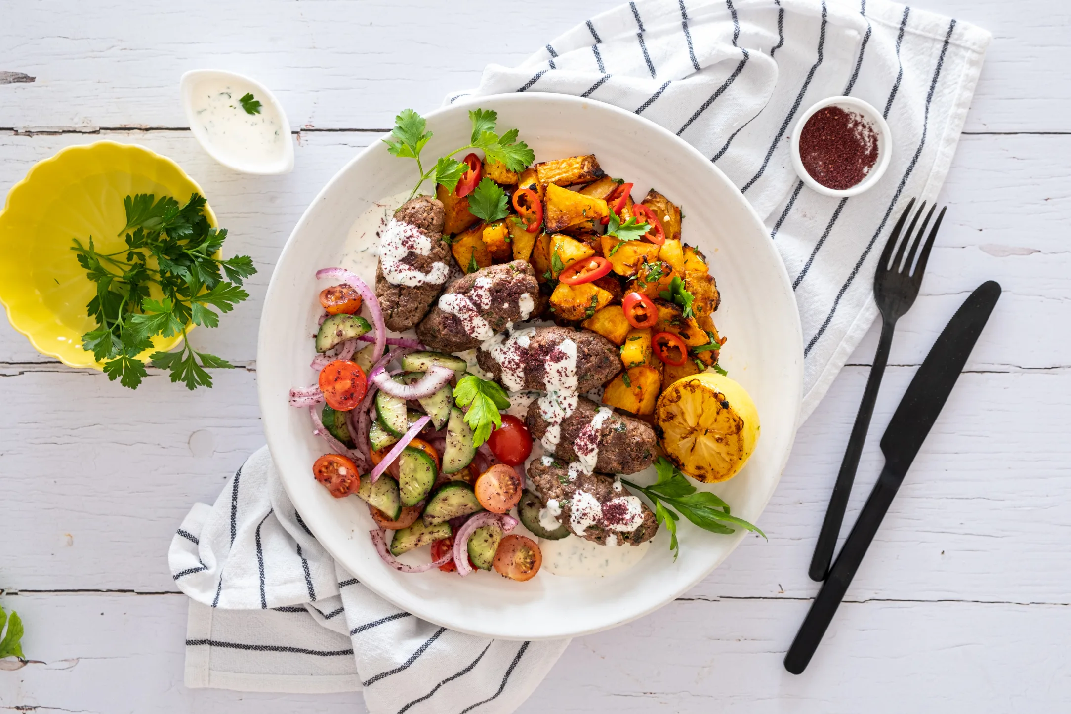 Lamb Kofta and Spicy Coriander Potatoes with Tarator Sauce and Cucumber Tomato Salad