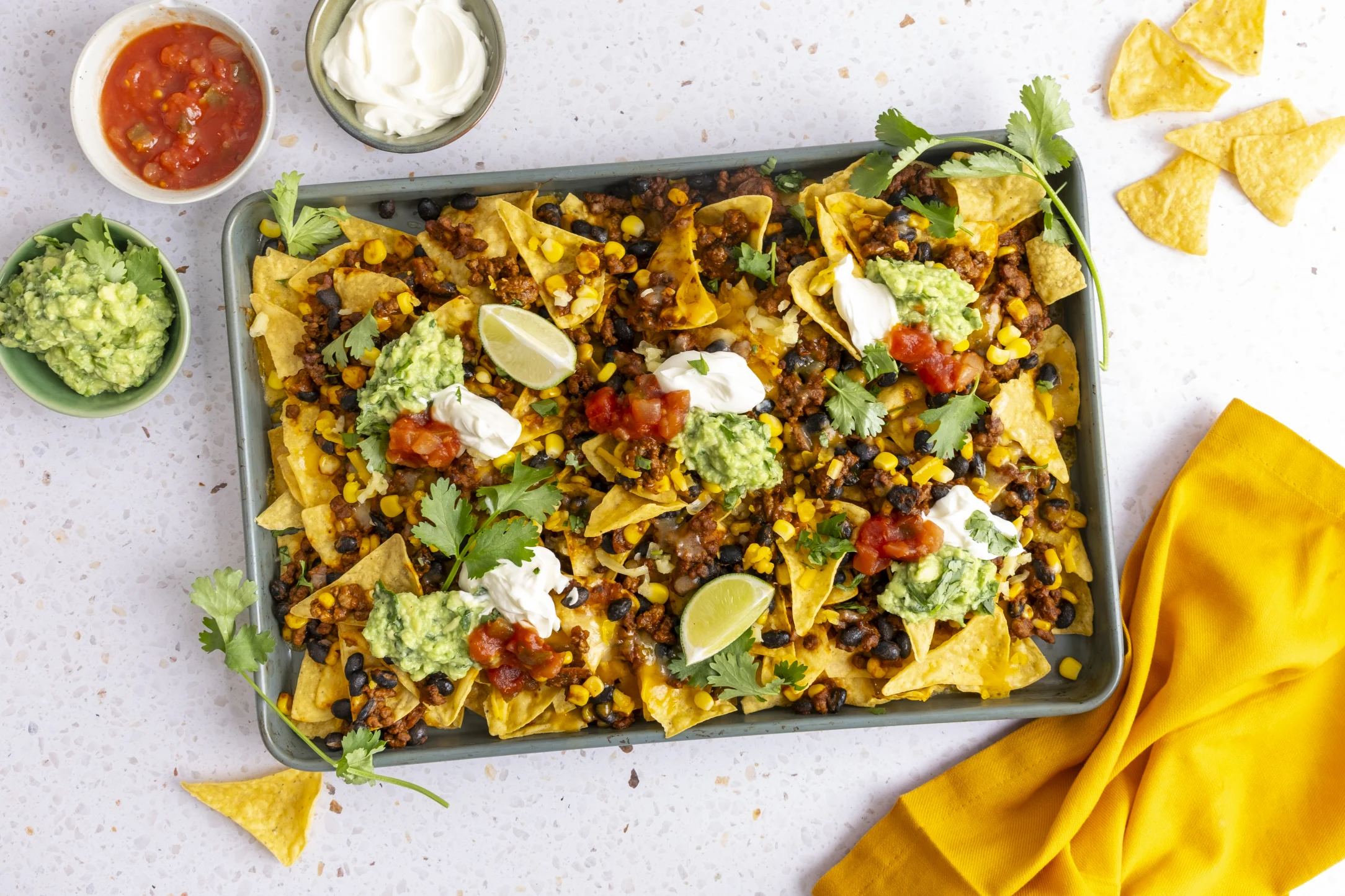 Loaded Cheesy Beef Nachos with Guacamole, Salsa, and Sour Cream