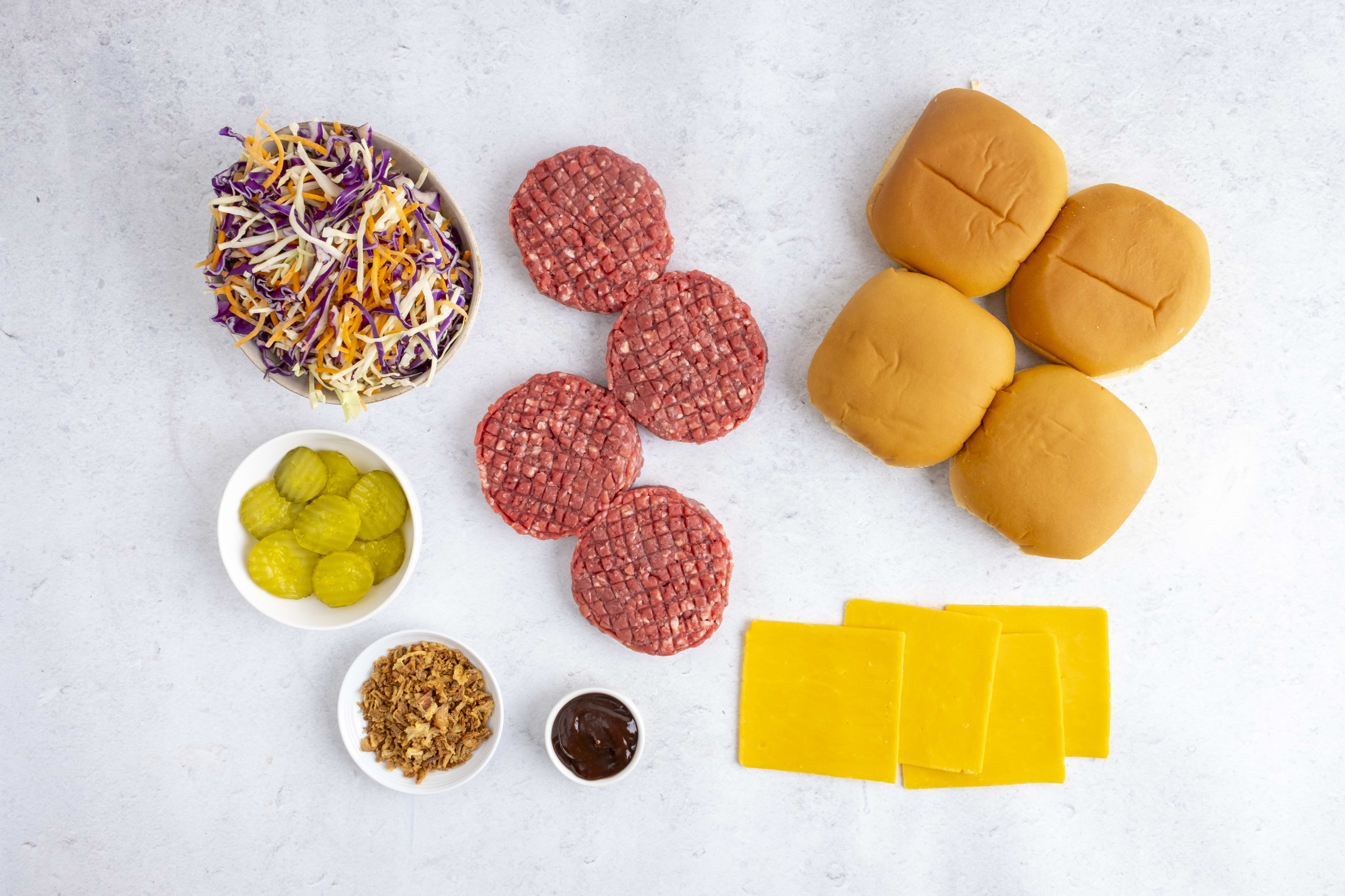 Smoky BBQ beef burger box contents: patties, buns, cheddar, slaw, crispy onions and sauces