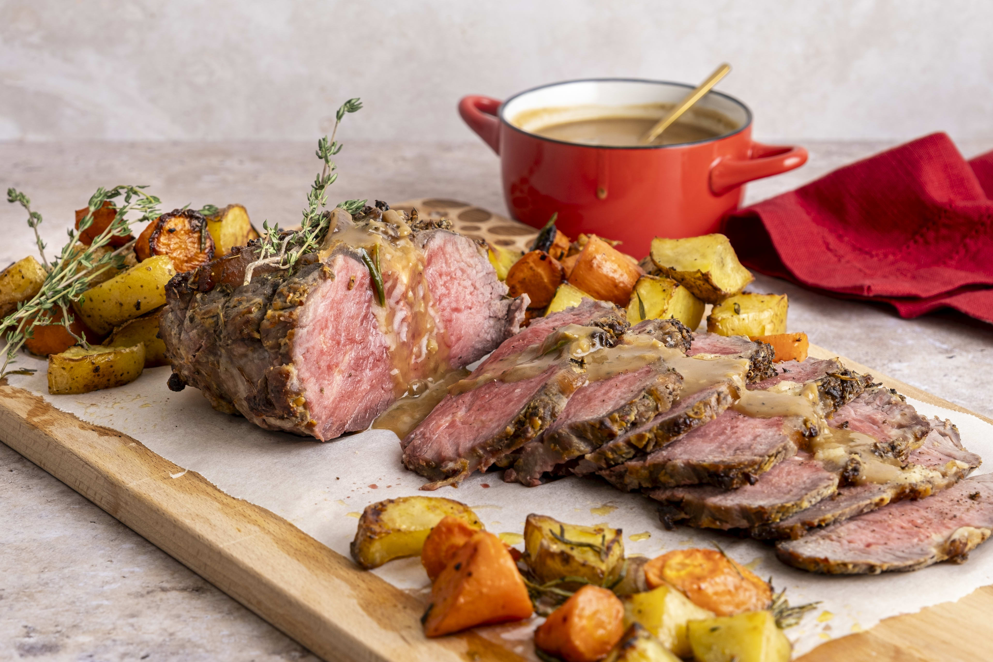Herb-crusted beef sirloin roast with potatoes, carrots and gravy
