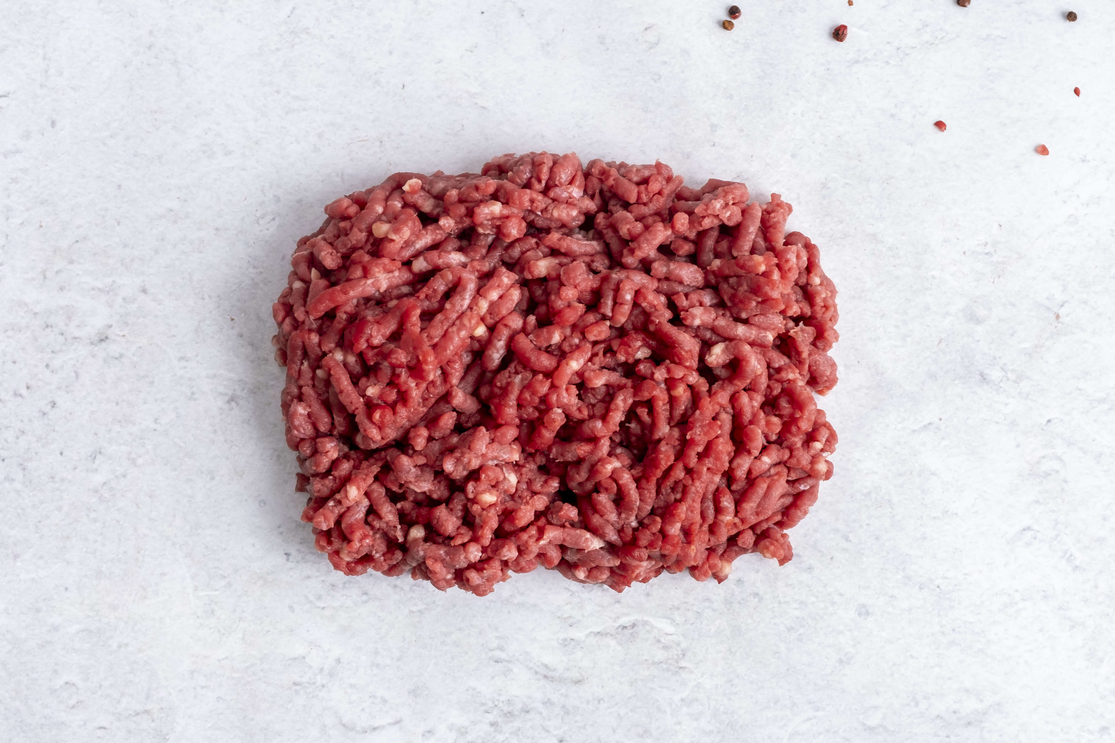 Grass fed beef mince, raw, on light marble