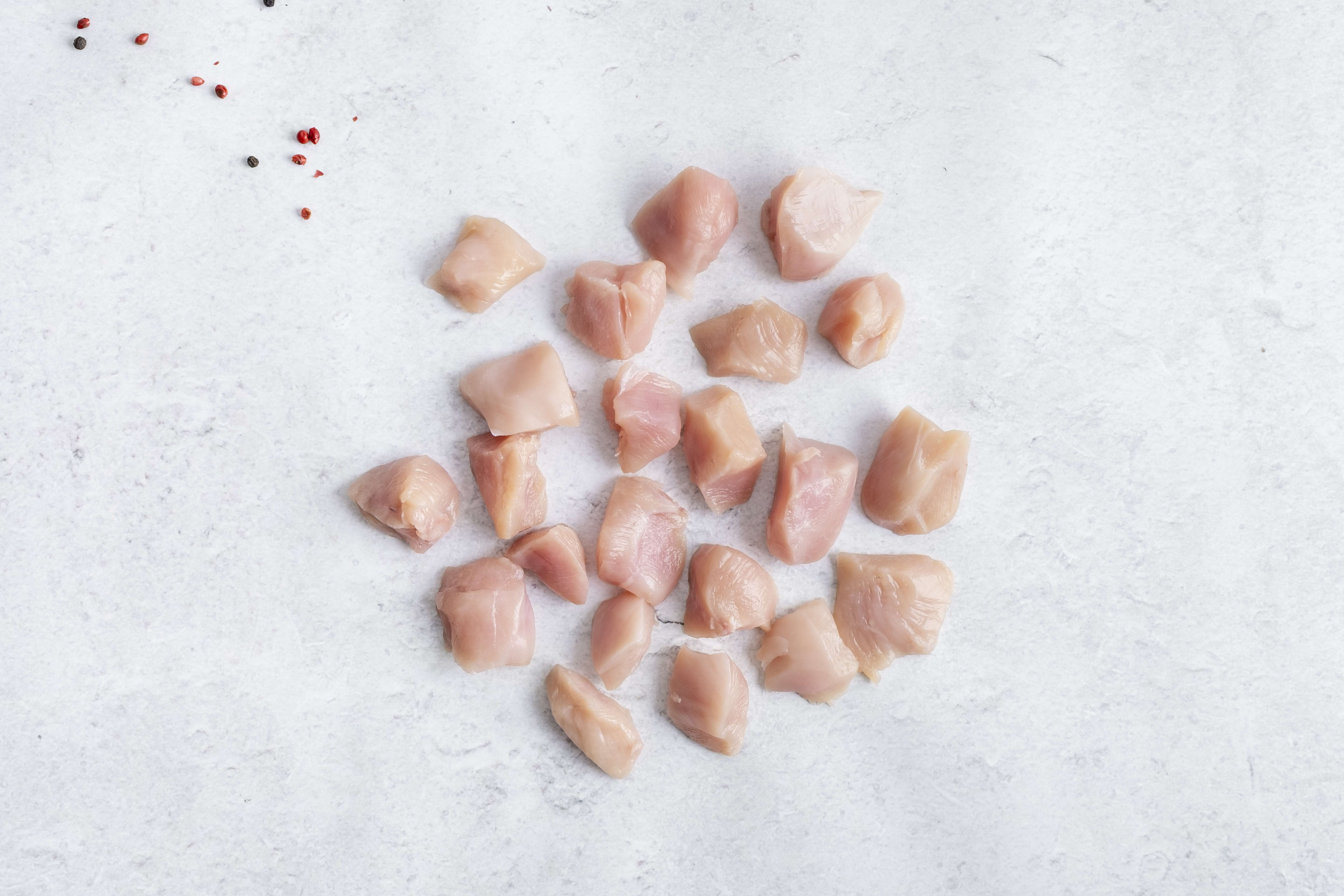Diced chicken breast, raw, on light marble