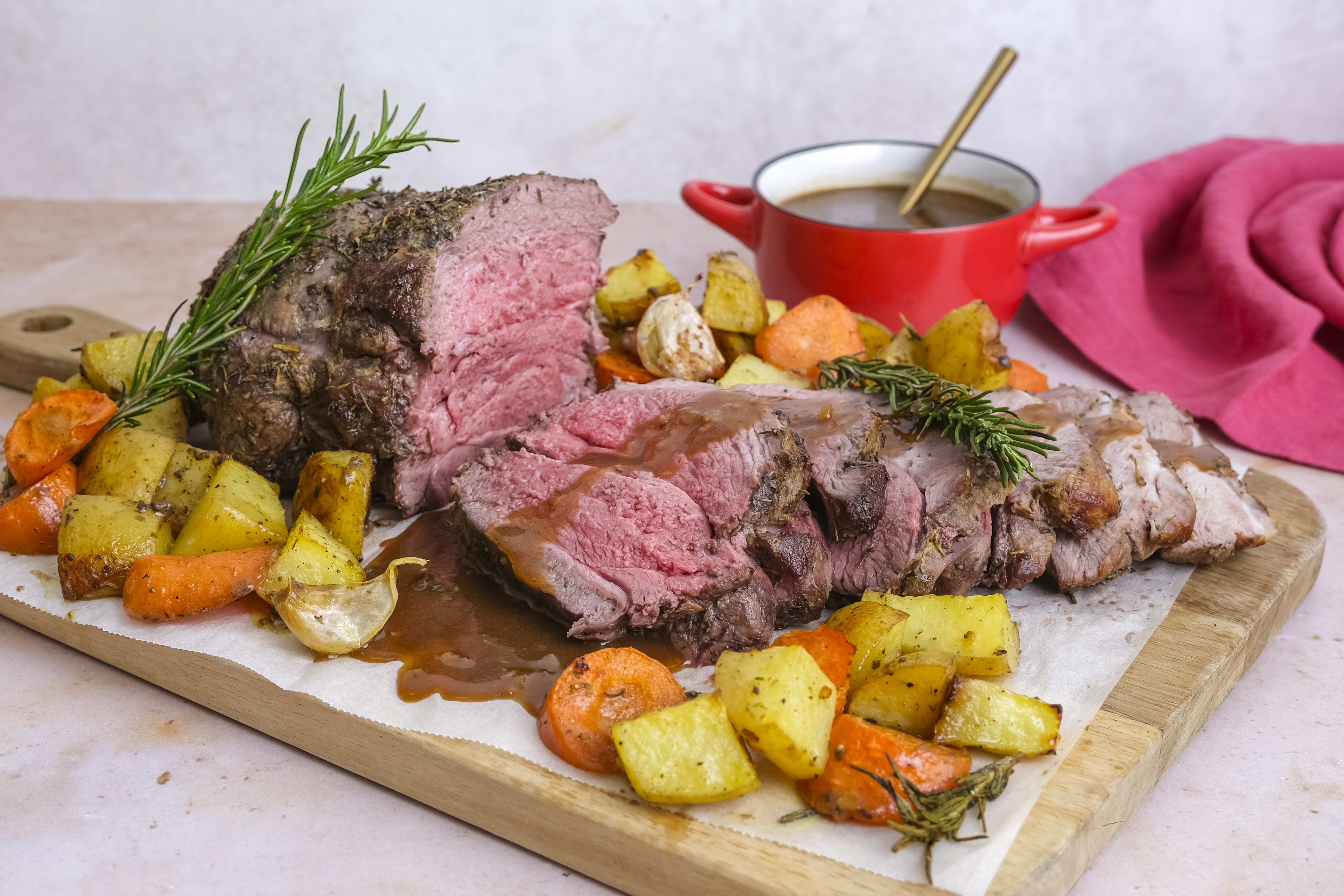 Herb-crusted lamb leg roast with potatoes, carrots and gravy
