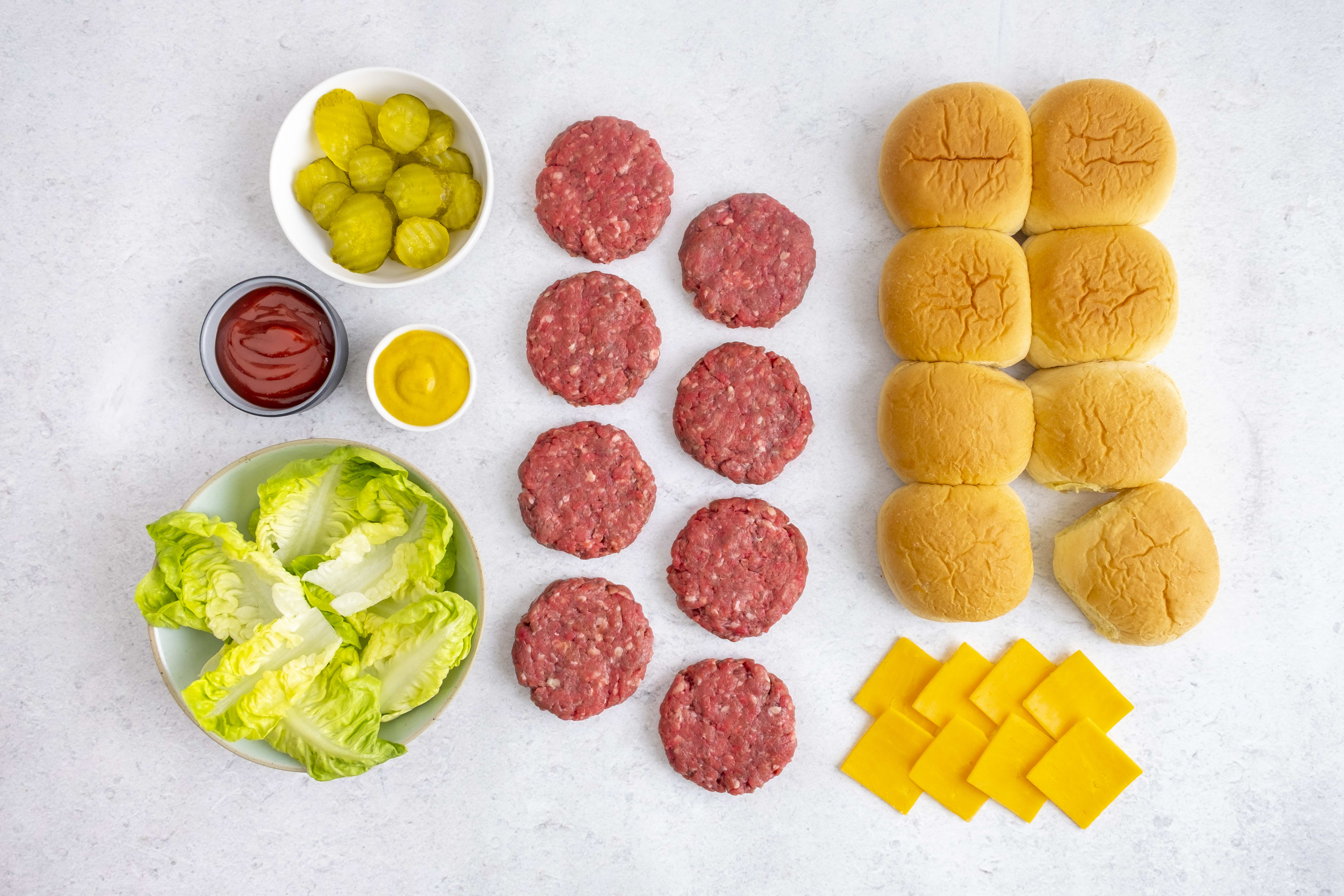 Classic beef slider box contents: slider patties, buns, cheddar, lettuce, pickles and sauces