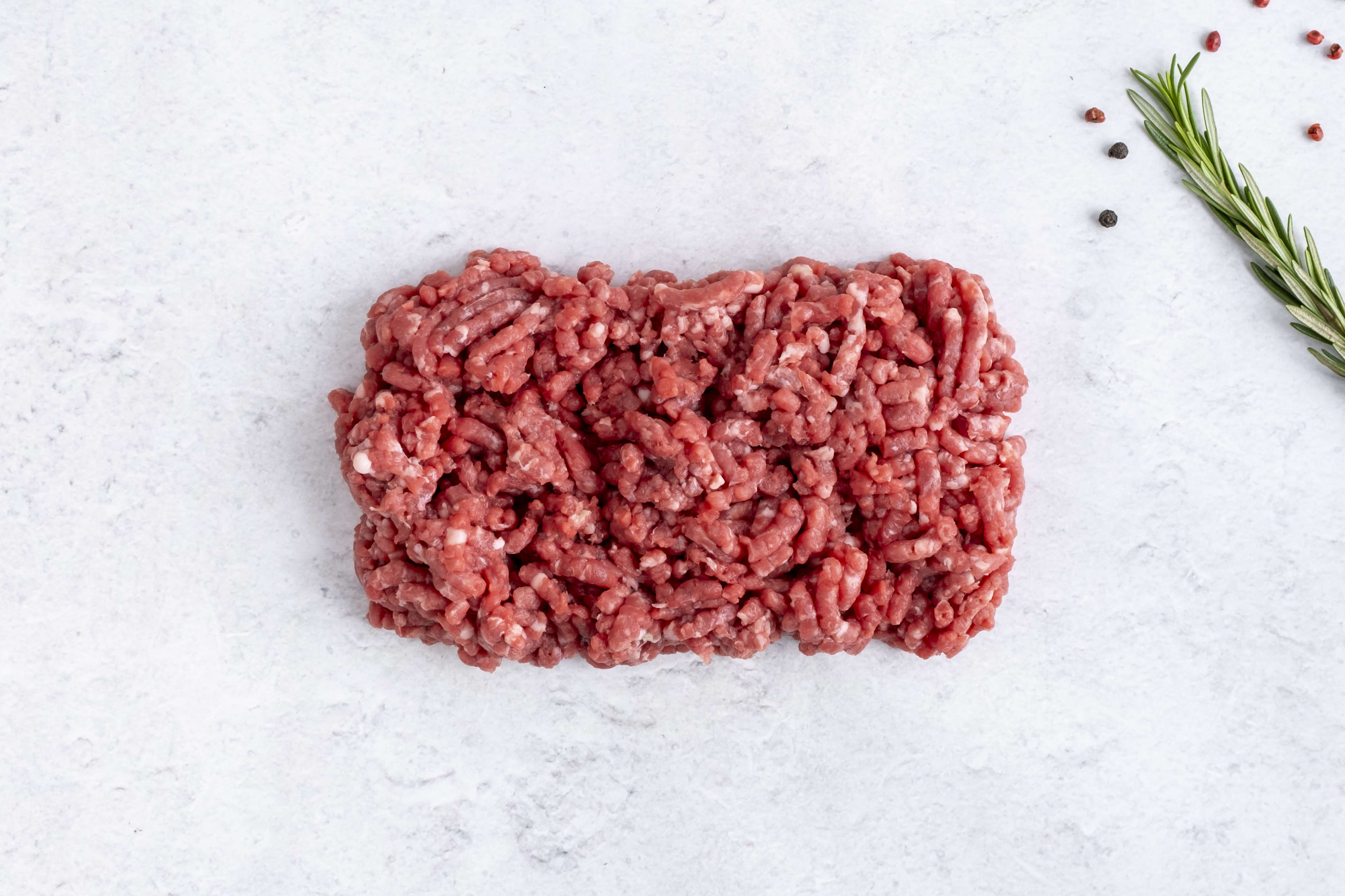Grass fed lean lamb mince, raw, on light marble