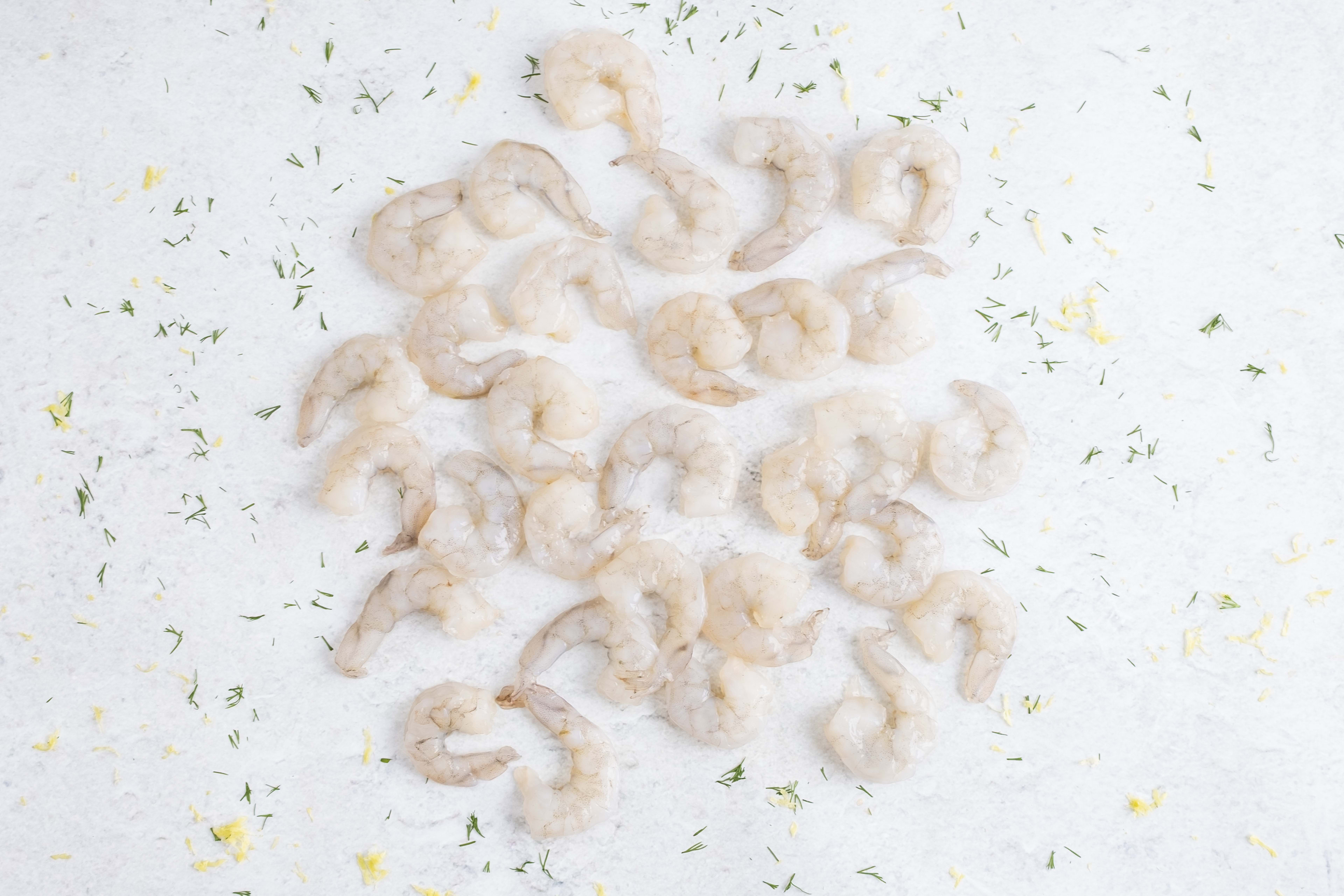 Peeled raw prawns on light marble