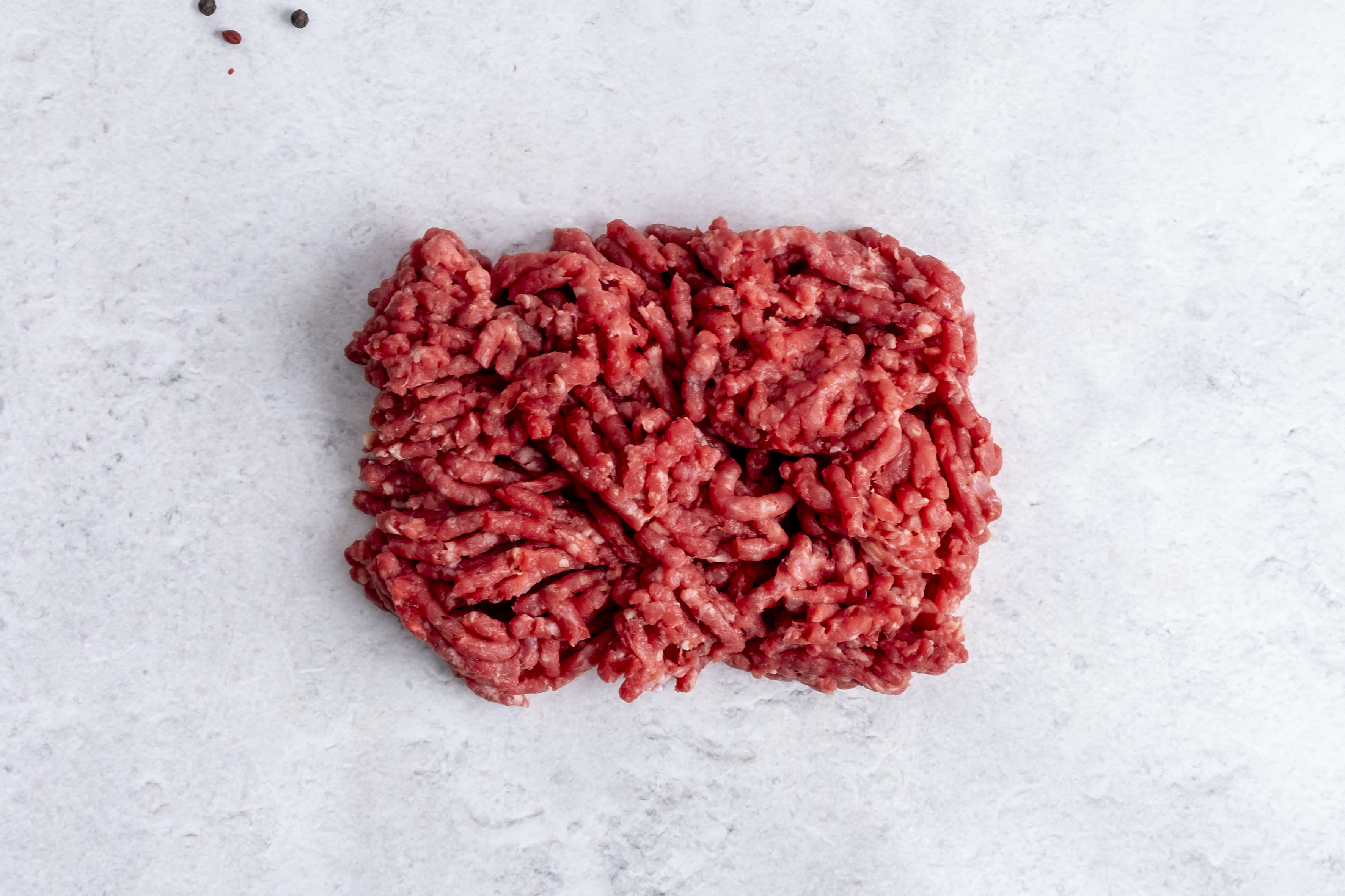 Grass fed lean beef mince, raw, on light marble