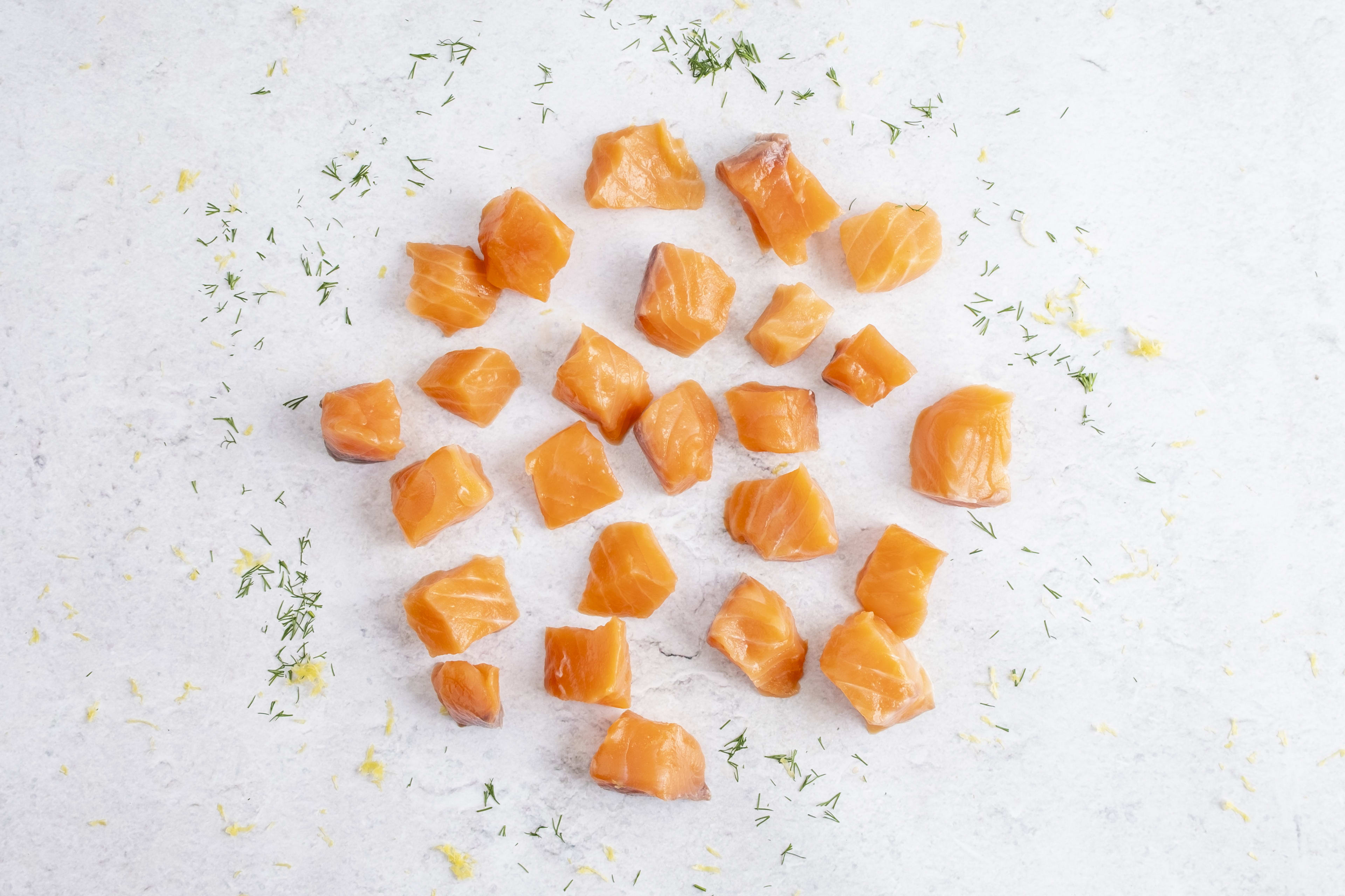 Salmon cubes, raw, on light marble