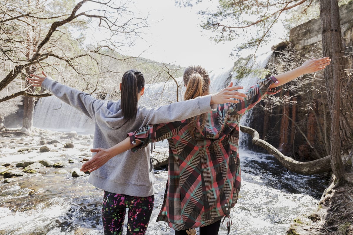 Dos mujeres con las manos levantadas frente a un río
