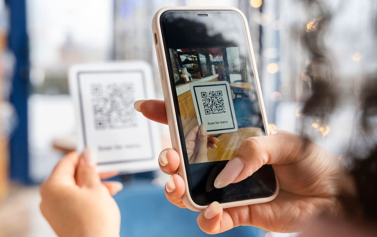 Una mujer escanea un código QR con su móvil