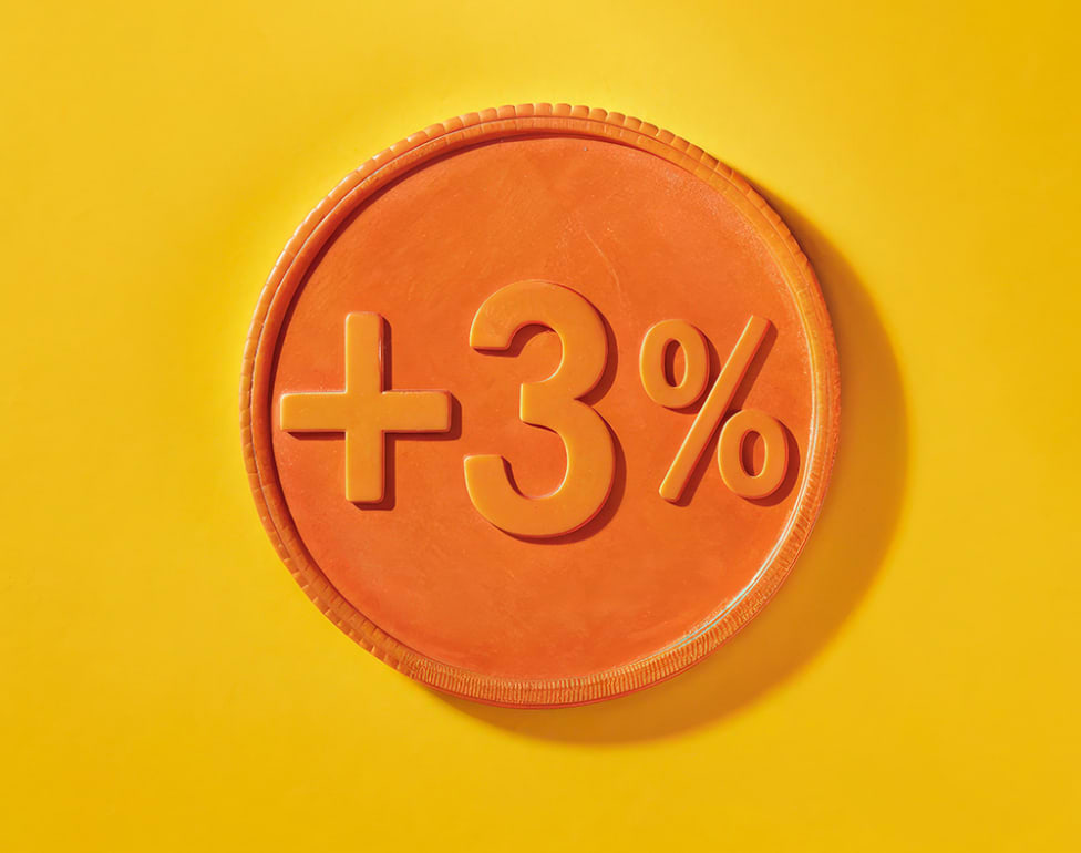 Moneda naranja con símbolo "+3%" sobre un fondo amarillo brillante.