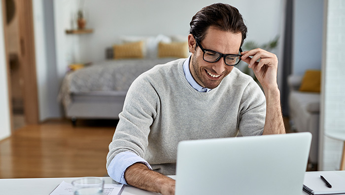 Hombre contento mira un ordenador