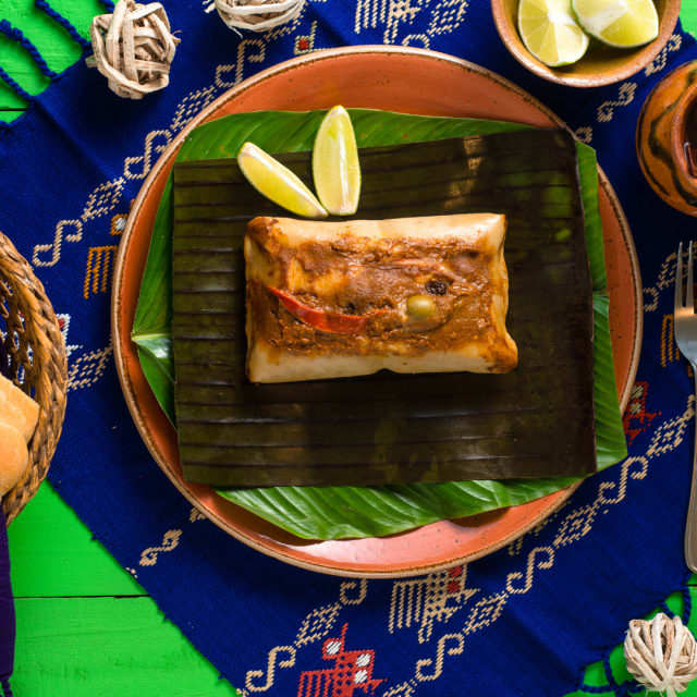 breaded and fried pastry on a banana leaf