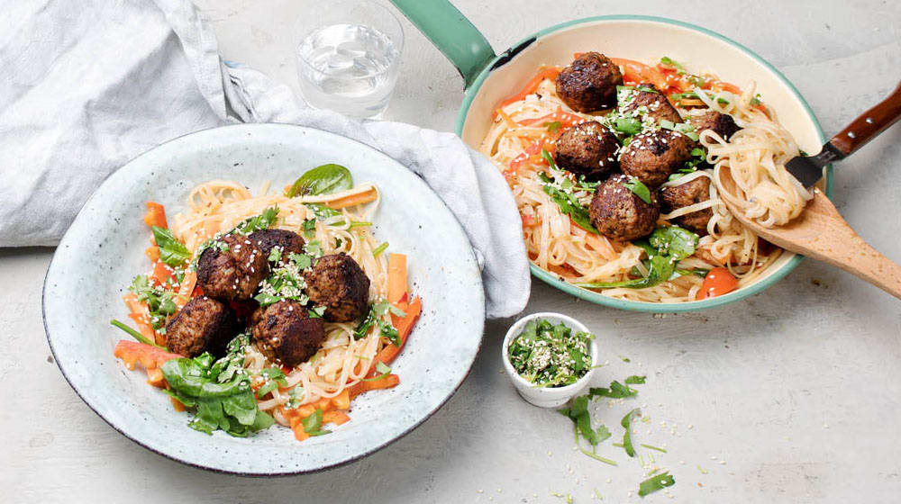 Asiatiska köttbullar och nudelsallad toppad med sesamfrön