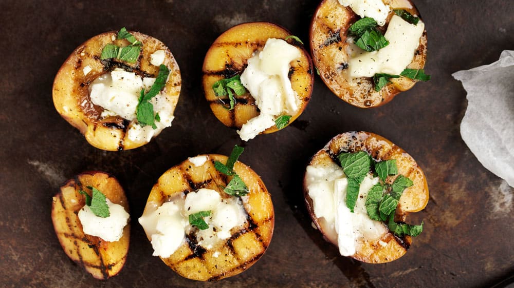 Grillade persikor med getost, mynta och olivolja