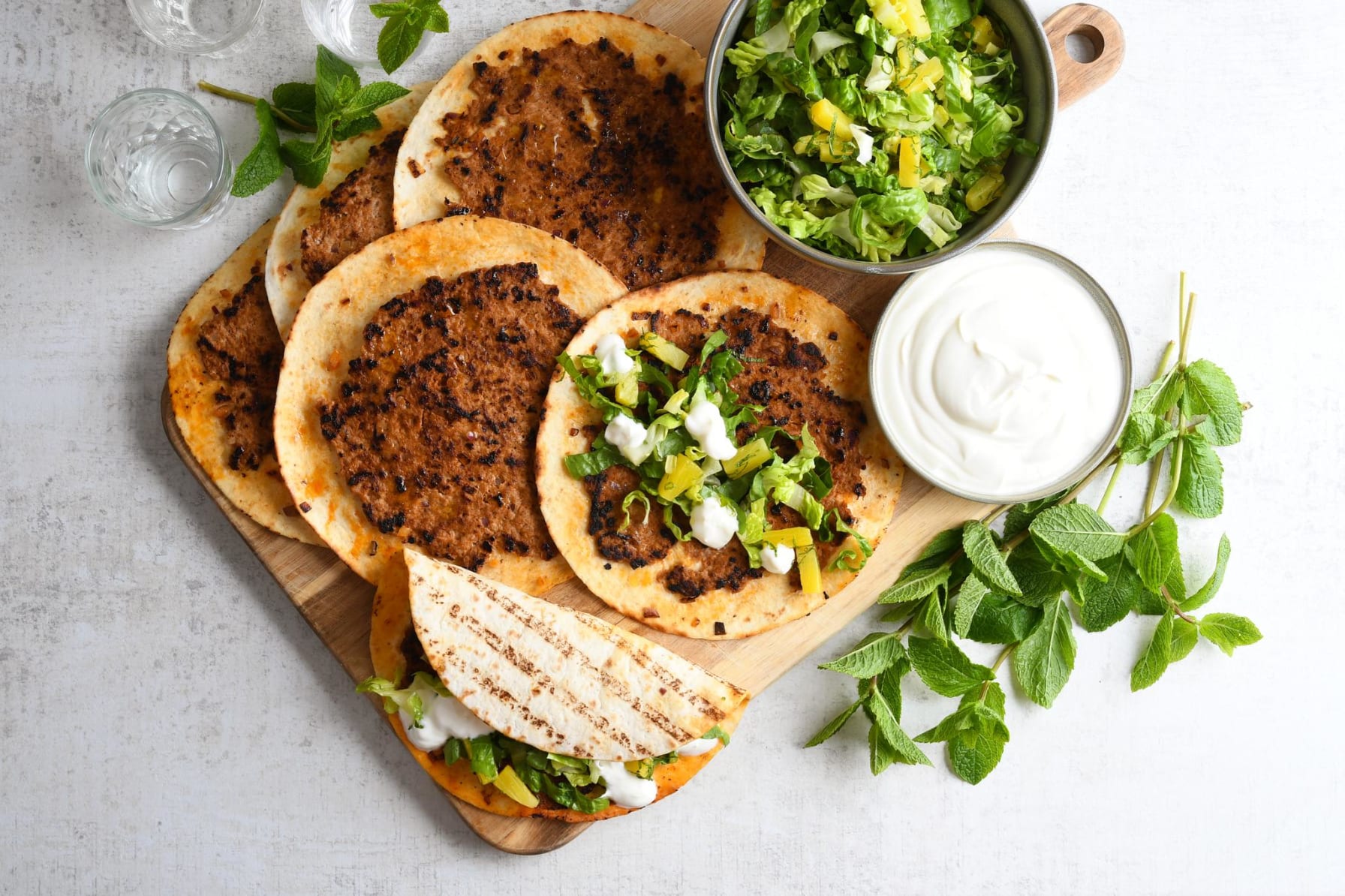 Smashed fläsktaco med gräddfil, ananas och myntasallad brevid