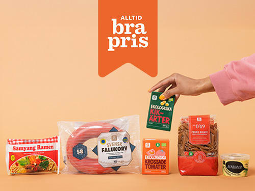 Olika matvaror står uppradade och en hand ställer in en förpackning kikärtor och i förgrunden syns en flagga med texten Alltid bra pris.