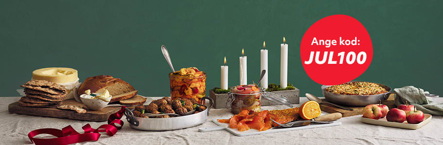 Ett klassiskt svensk julbord står uppdukat med fyra tända adventsljus i bakgrunden och framför syns en bubbla med texten "Ange kod: JUL100".