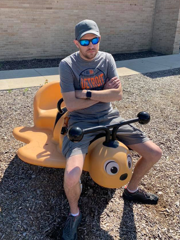 Jasen sitting on childrens playground equipment.