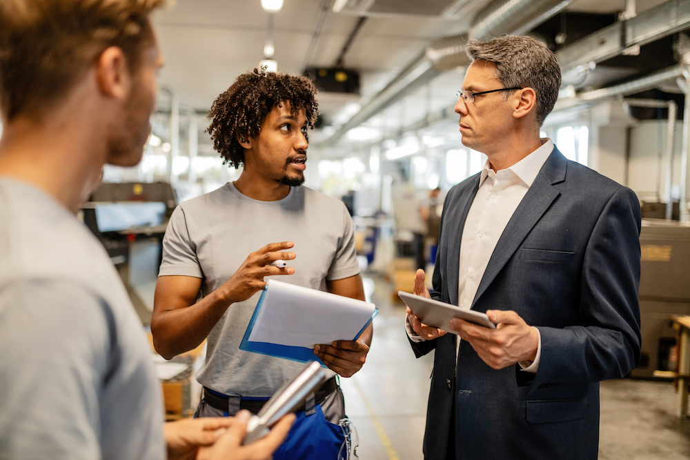 foreman explaining to his manager and a colleague
